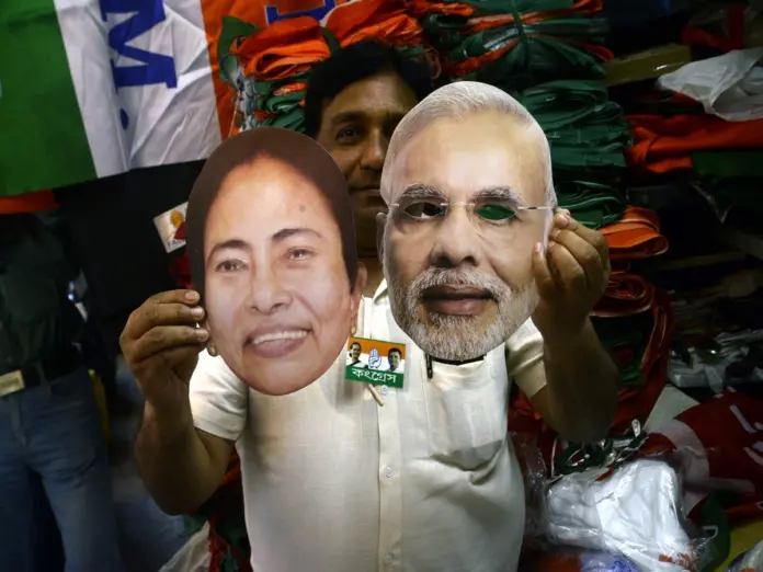 Kolkata: A shopkeeper shows the masks of Prime Minister and BJP leader Narendra Modi and West Bengal Chief Minister and TMC supremo Mamata Banerjee ahead of 2019 Lok Sabha elections, in Kolkata on March 29, 2019. (Photo: Kuntal Chakrabarty/IANS)