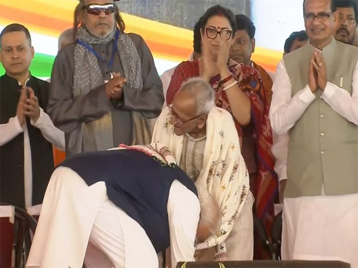 Prime Minister Narendra Modi seeks blessings of veteran BJP worker Makhanlal Sarkar during the swearing-in ceremony of West Bengal Chief Minister-designate Suvendu Adhikari in Kolkata (Photo- IANS)