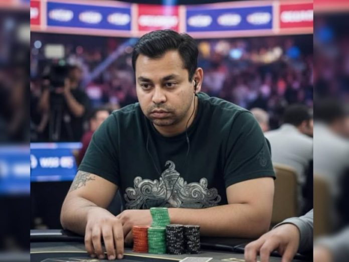 Man sits at a poker table concentrating, wearing a dark green shirt and headphones, with poker chips stacked in front of him (red, green, black).