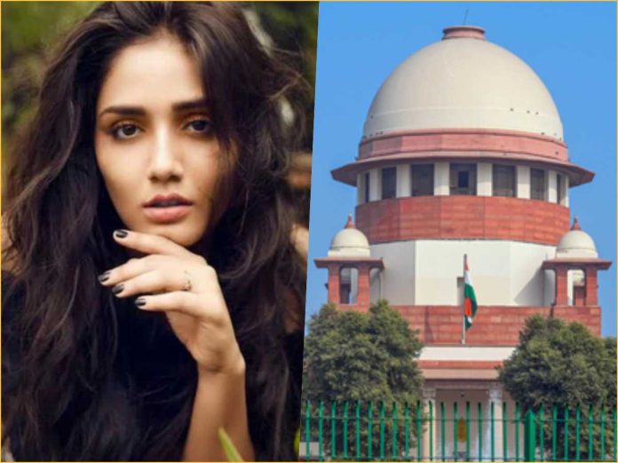 Portrait of a woman with long dark hair on the left, and the Indian Parliament building with a blue sky on the right.