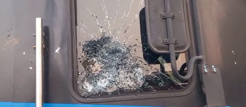 202606143824606 - bolebharat Window with heavy shattered glass radiating in a spiderweb pattern from a central impact on a dark door.