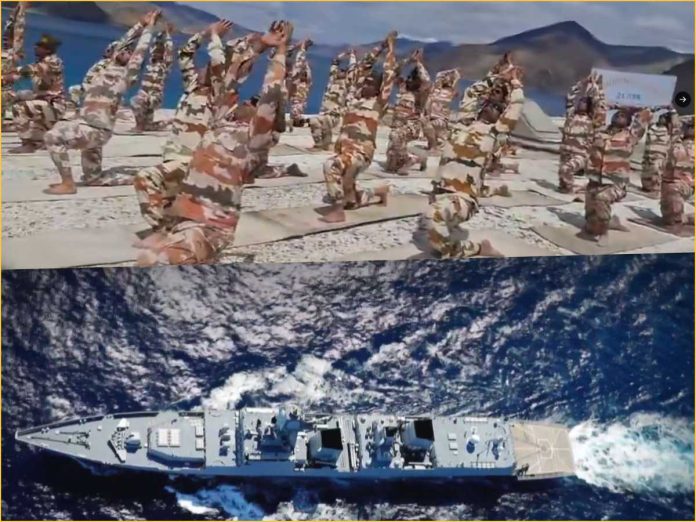 Group of camouflaged soldiers doing yoga-like stretches on a rocky beach with mountains in the background; a naval ship moves through the ocean below the scene.