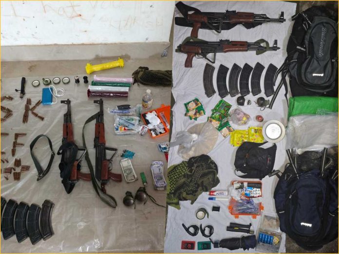 Assorted weapons, ammunition, and survival gear spread on plastic sheets: rifles, magazines, backpacks, and medical supplies.