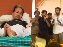 Split image: left side shows a man lying in bed with feet visible; right side shows a man with a microphone addressing a crowd on a stage as others applaud nearby.