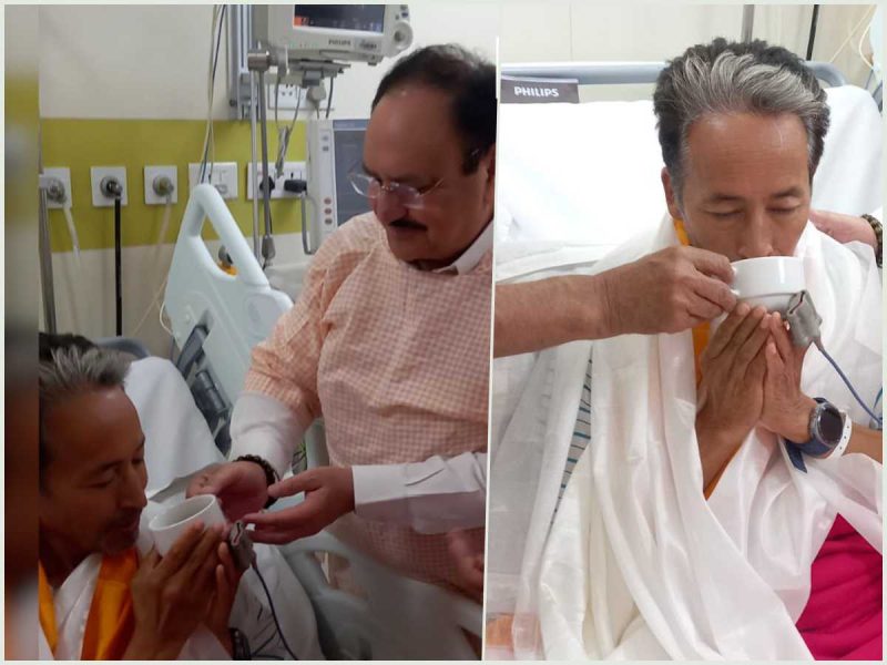 Split-screen scene in a hospital: a patient in bed is assisted by a caregiver handing him a cup, with medical equipment in view.