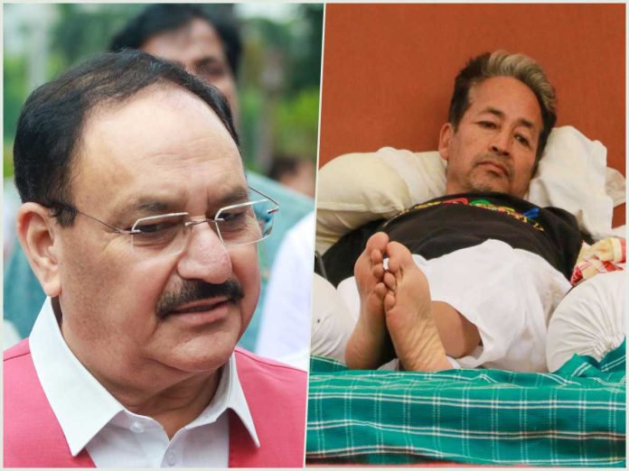 Split image: left a man in a pink jacket with glasses outdoors; right a man lying in a coffin, covered with white sheets and a green blanket, feet visible.