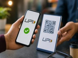 UPI पेमेंट पर अब देना होगा शुल्क? लोकसभा में बिल पास; कब से लागू होंगे ये बदलाव Two people at a cafe show a phone with a UP! app green checkmark next to a QR code card on a table.