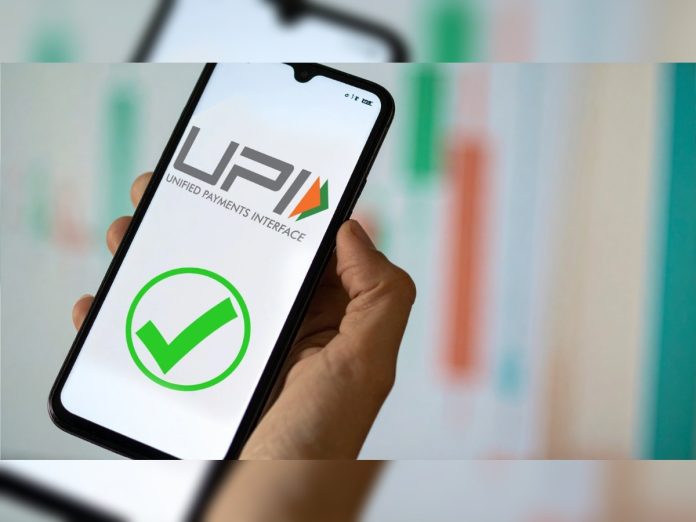 Hand holding a smartphone displaying the UPI logo and a green checkmark.